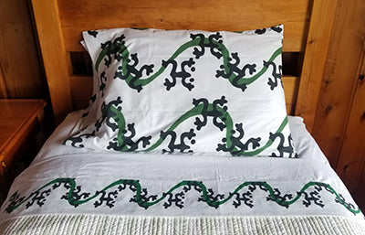Flat sheet with a border like a green ribbon with black Taino Coqui frogs.