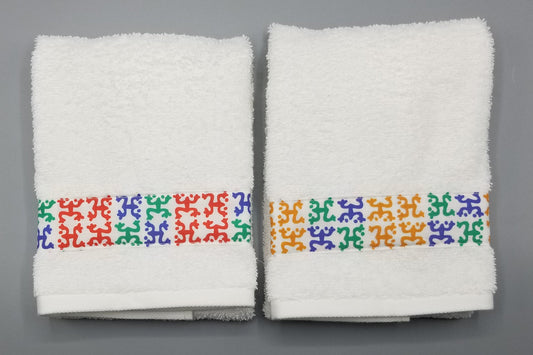 White hand towels with a border of colorful coqui Frogs